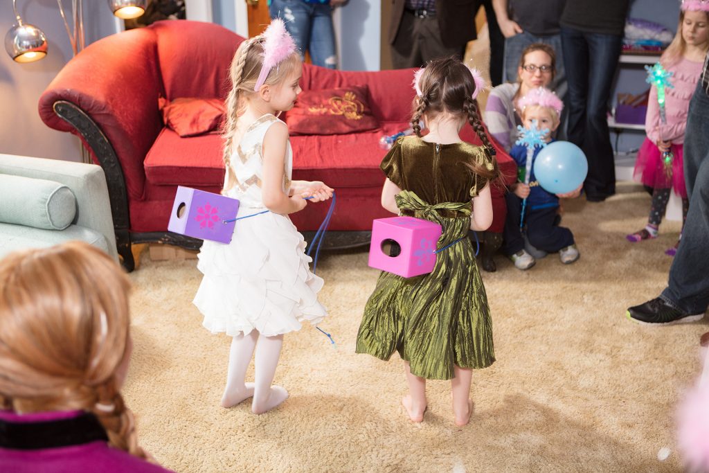 Two children playing a party game at a princess-themed birthday party.