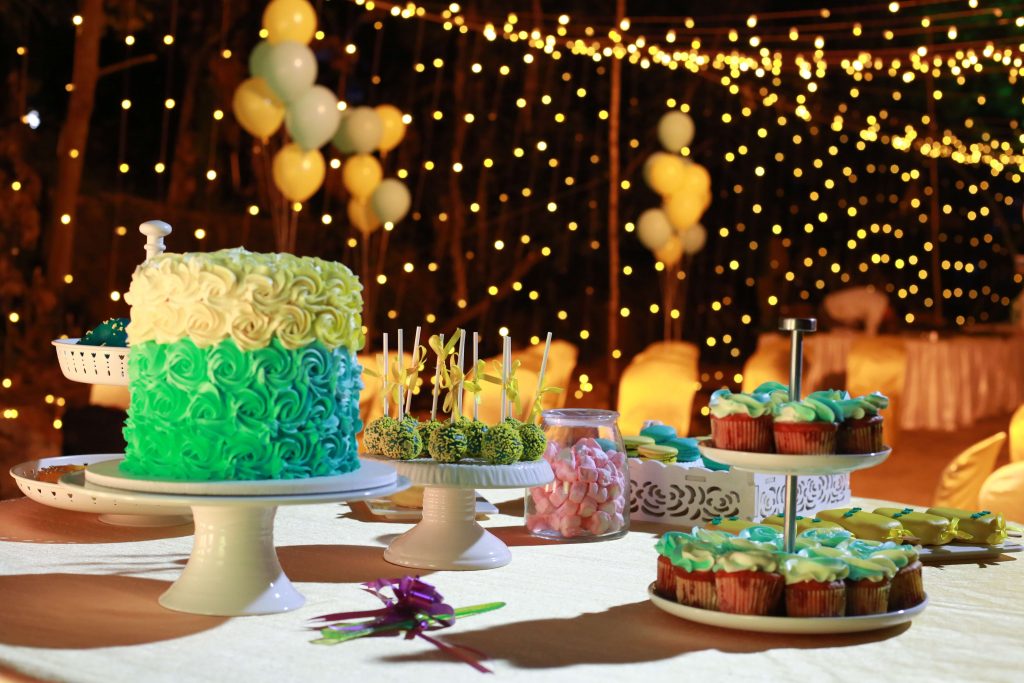 A green cake, green cupcakes, and green cake pops are displayed at a Princess Merida birthday party