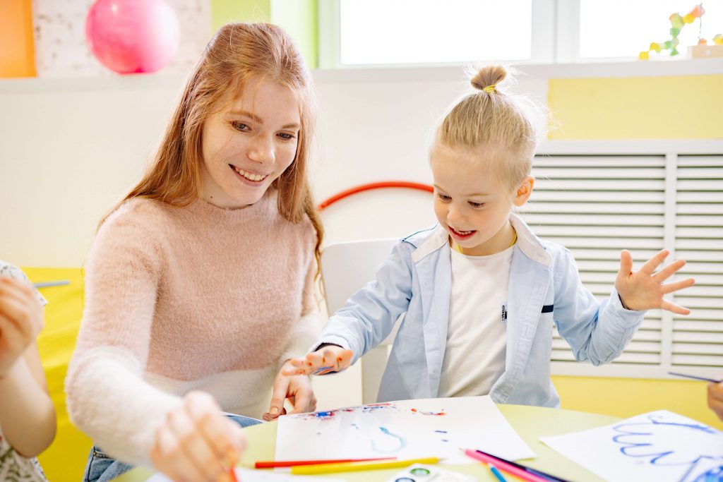 A small girl and her mother paint together