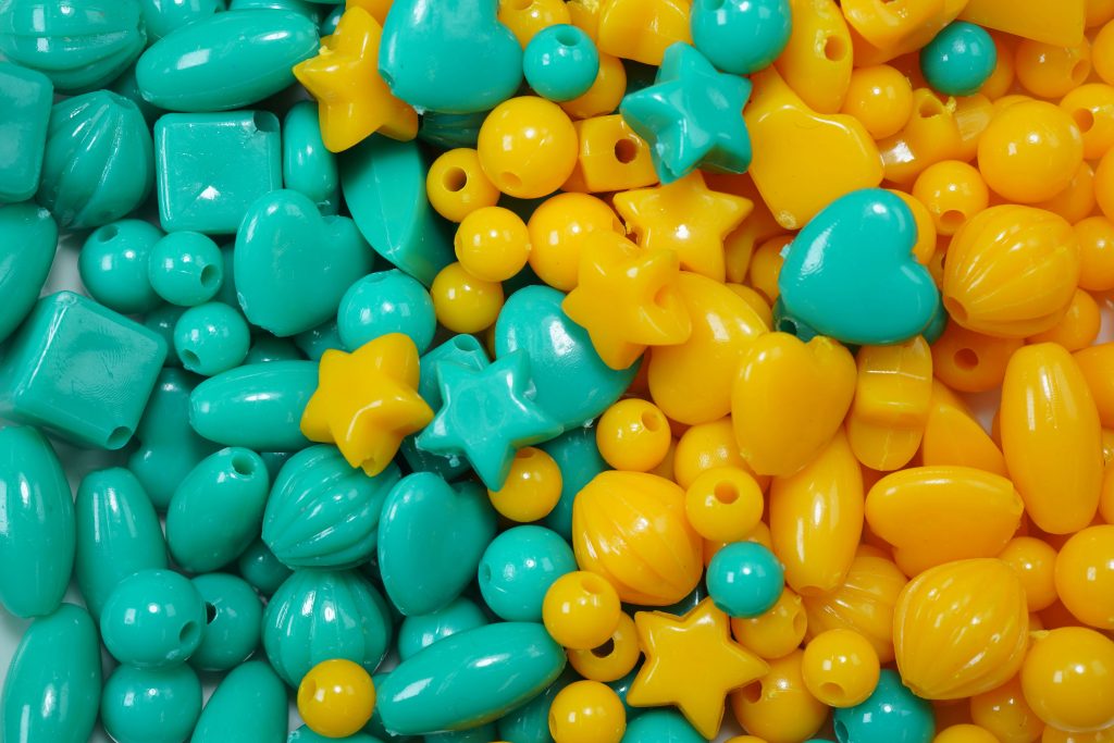 Teal and yellow beads are displayed mixed together